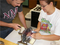 Image of Engineering student demonstrates meat slicer 6/27/07 food preservation workshop